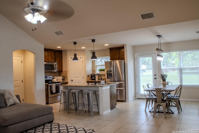 2073 Robin Hood, Canyon Lake, TX 78133 - kitchen featuring stainless steel appliances, baseboards, a breakfast bar area, a ceiling fan, and light stone countertops