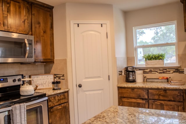 2073 Robin Hood, Canyon Lake, TX 78133 - kitchen featuring stainless steel appliances, tasteful backsplash, and light stone countertops