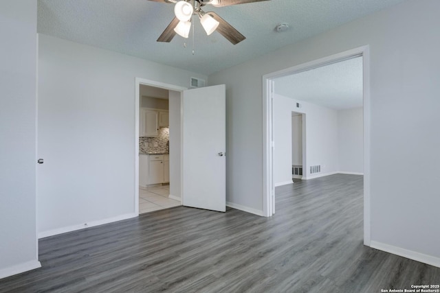 8915 Datapoint Unit 49A, San Antonio, TX 78229 - spare room with ceiling fan, wood finished floors, a smoke detector, and baseboards
