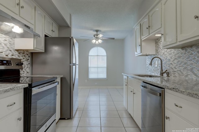 8915 Datapoint Unit 49A, San Antonio, TX 78229 - kitchen with appliances with stainless steel finishes, a sink, under cabinet range hood, light tile patterned flooring, and ceiling fan