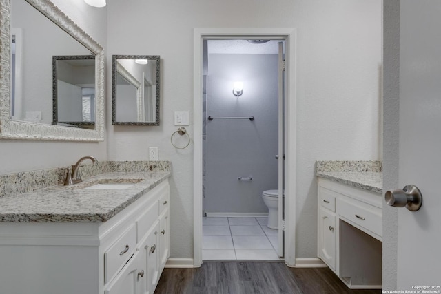 8915 Datapoint Unit 49A, San Antonio, TX 78229 - bathroom featuring vanity, wood finished floors, toilet, and baseboards