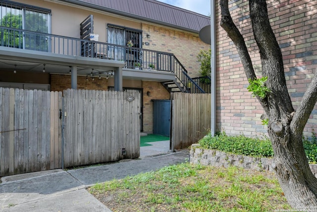 8915 Datapoint Unit 49A, San Antonio, TX 78229 - view of home's exterior with brick siding, metal roof, stairway, and stucco siding
