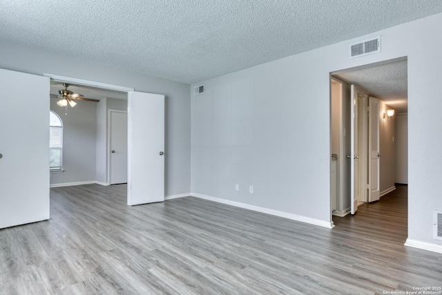 8915 Datapoint Unit 49A, San Antonio, TX 78229 - empty room featuring a textured ceiling, wood finished floors, baseboards, and a ceiling fan
