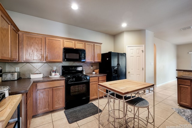 20710 Meandering Cir, San Antonio, TX 78258 - kitchen featuring black appliances, decorative backsplash, light tile patterned flooring, dark countertops, and recessed lighting