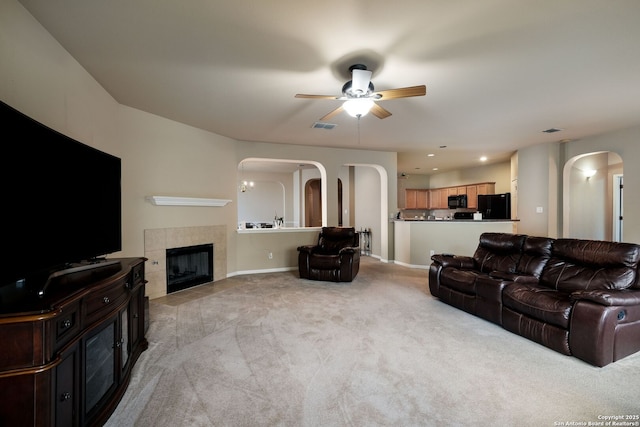 20710 Meandering Cir, San Antonio, TX 78258 - carpeted living room with arched walkways, ceiling fan, baseboards, and a tile fireplace