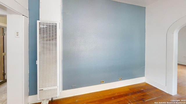 519 Huisache, San Antonio, TX 78212 - empty room featuring a heating unit, arched walkways, wood finished floors, and baseboards