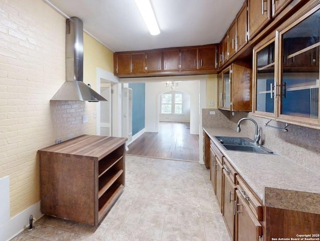 519 Huisache, San Antonio, TX 78212 - kitchen with a sink, wall chimney exhaust hood, arched walkways, open shelves, and glass insert cabinets