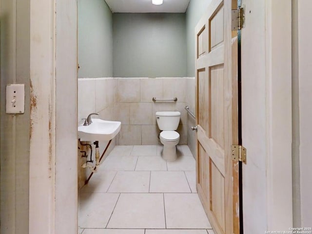 519 Huisache, San Antonio, TX 78212 - bathroom featuring toilet, tile walls, tile patterned flooring, a wainscoted wall, and a sink