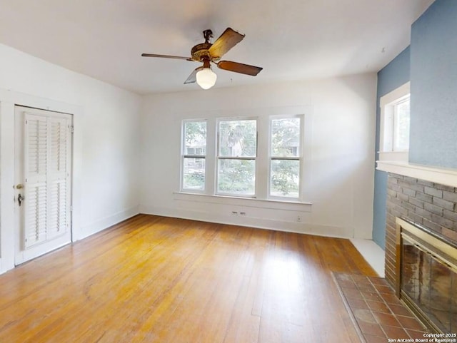 519 Huisache, San Antonio, TX 78212 - unfurnished living room featuring plenty of natural light, wood finished floors, a ceiling fan, and a brick fireplace