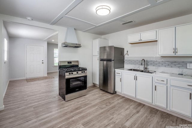 326 Sublett, San Antonio, TX 78223 - kitchen with appliances with stainless steel finishes, a sink, white cabinets, premium range hood, and light wood-style floors