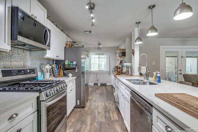 6034 Royal, San Antonio, TX 78239 - kitchen with appliances with stainless steel finishes, a sink, white cabinetry, tasteful backsplash, and wood finished floors