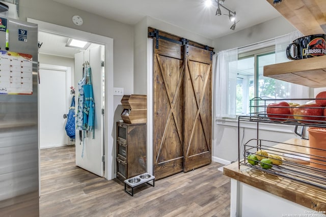 6034 Royal, San Antonio, TX 78239 - entrance foyer with wood finished floors, a barn door, and baseboards
