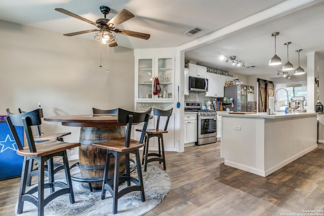 6034 Royal, San Antonio, TX 78239 - kitchen featuring appliances with stainless steel finishes, a ceiling fan, backsplash, white cabinets, and dark wood-style floors