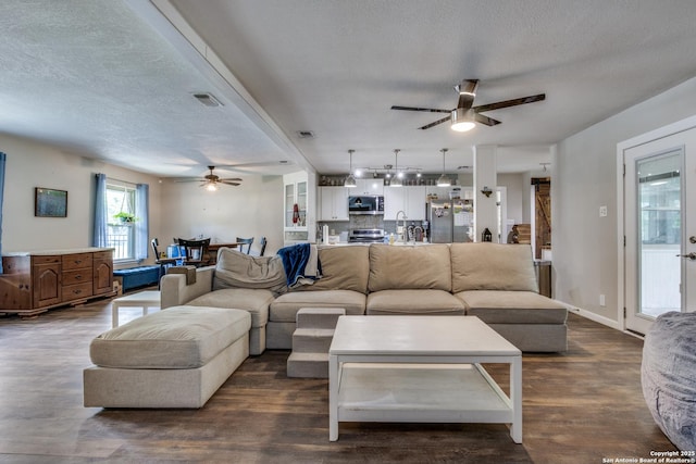 6034 Royal, San Antonio, TX 78239 - living area featuring a ceiling fan, a textured ceiling, and dark wood-style flooring