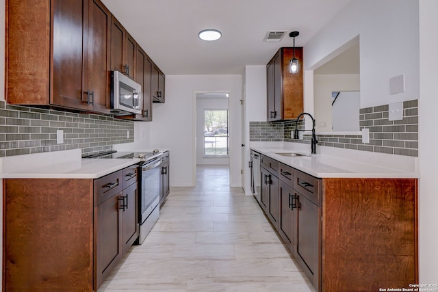 3250 Bear Spgs, San Antonio, TX 78245 - kitchen with stainless steel appliances, a sink, decorative backsplash, and light countertops
