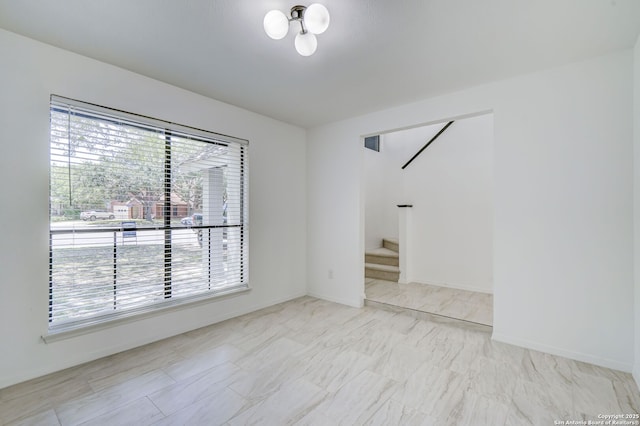 3250 Bear Spgs, San Antonio, TX 78245 - spare room with stairway, baseboards, marble finish flooring, and a chandelier