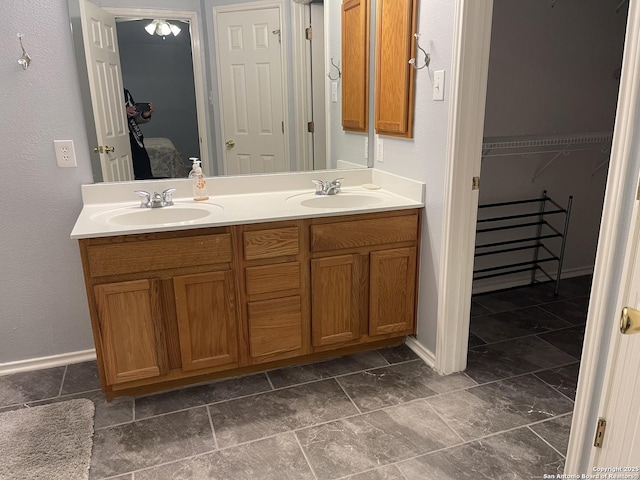 4122 Chinkapin Oak, San Antonio, TX 78223 - full bathroom featuring double vanity, a walk in closet, and baseboards