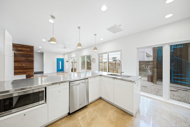 543 Leigh, San Antonio, TX 78210 - kitchen with stainless steel appliances, stainless steel countertops, recessed lighting, white cabinetry, and decorative light fixtures
