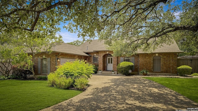 7011 Washita Way, San Antonio, TX 78256 - view of front of property featuring an attached garage, brick siding, and a shingled roof