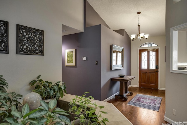 7011 Washita Way, San Antonio, TX 78256 - foyer entrance featuring a chandelier, vaulted ceiling, dark wood-style floors, and baseboards