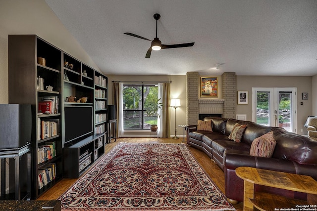 7011 Washita Way, San Antonio, TX 78256 - living room with a textured ceiling, a ceiling fan, light wood-style flooring, a brick fireplace, and lofted ceiling