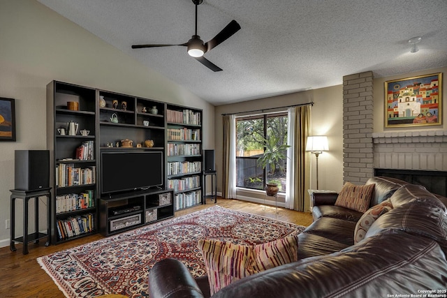 7011 Washita Way, San Antonio, TX 78256 - living room featuring a textured ceiling, a ceiling fan, lofted ceiling, wood finished floors, and a fireplace