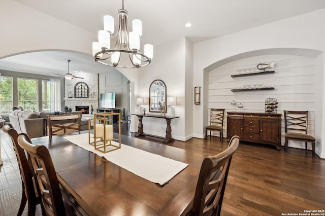 1036 Carriage, New Braunfels, TX 78132 - dining area featuring arched walkways, a fireplace, wood finished floors, a ceiling fan, and a chandelier