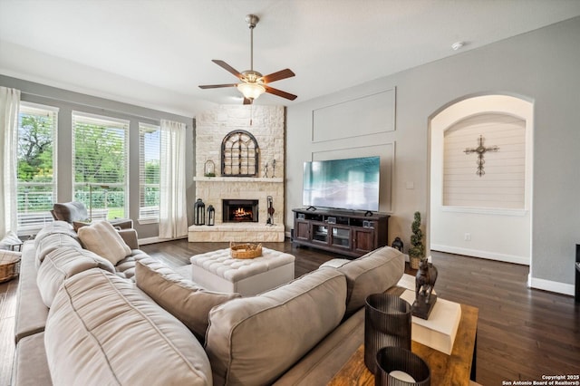 1036 Carriage, New Braunfels, TX 78132 - living room featuring a ceiling fan, dark wood finished floors, baseboards, a fireplace, and arched walkways
