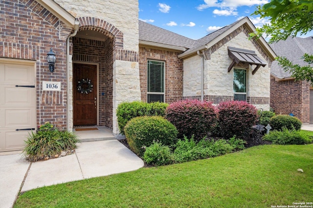 1036 Carriage, New Braunfels, TX 78132 - doorway to property with stone siding, a lawn, roof with shingles, brick siding, and an attached garage