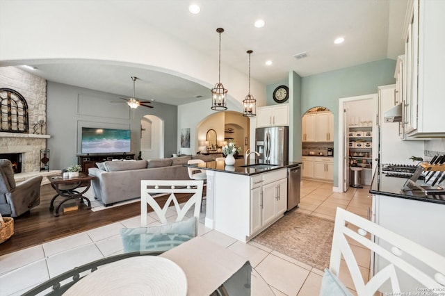 1036 Carriage, New Braunfels, TX 78132 - kitchen featuring arched walkways, stainless steel appliances, dark countertops, under cabinet range hood, and open floor plan