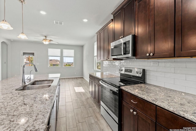 164 Antler Bnd, San Antonio, TX 78253 - kitchen featuring stainless steel appliances, backsplash, ceiling fan, wood finish floors, and hanging light fixtures
