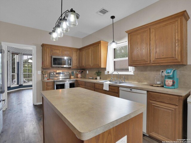 1775 Jasons N, New Braunfels, TX 78130 - kitchen with appliances with stainless steel finishes, a sink, dark wood-type flooring, decorative backsplash, and light countertops