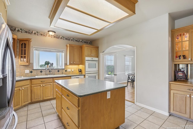 269 Red Rose, Spring Branch, TX 78070 - kitchen with stainless steel fridge, double oven, light tile patterned flooring, arched walkways, and plenty of natural light
