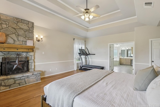 269 Red Rose, Spring Branch, TX 78070 - bedroom with a tray ceiling, wood finished floors, a fireplace, crown molding, and ensuite bathroom