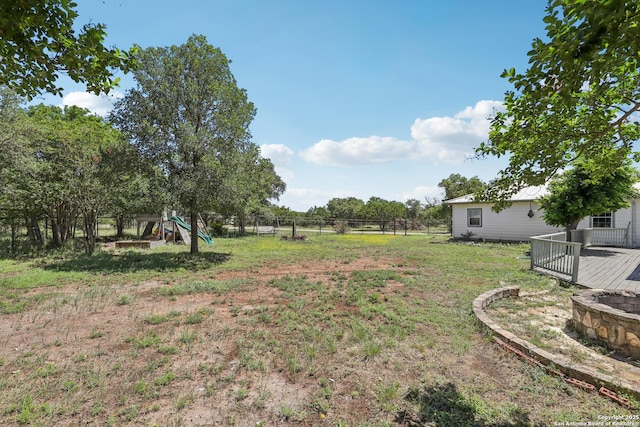 269 Red Rose, Spring Branch, TX 78070 - view of yard featuring a fire pit, a playground, and a wooden deck