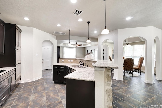 8126 Powderhorn Run, San Antonio, TX 78255 - kitchen featuring a sink, arched walkways, baseboards, recessed lighting, and a ceiling fan