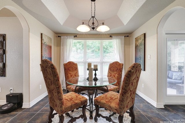 8126 Powderhorn Run, San Antonio, TX 78255 - dining area featuring arched walkways, healthy amount of natural light, a tray ceiling, and baseboards