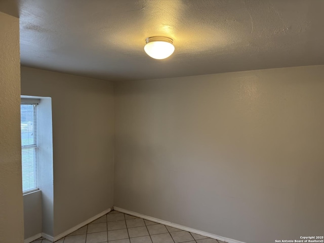 1715 Parnell, San Antonio, TX 78224 - spare room featuring healthy amount of natural light, a textured ceiling, light tile patterned floors, and baseboards