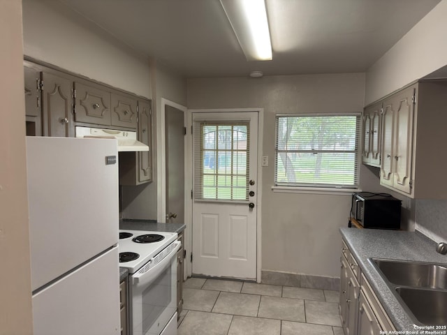 1715 Parnell, San Antonio, TX 78224 - kitchen featuring white appliances, a sink, under cabinet range hood, light tile patterned floors, and gray cabinetry