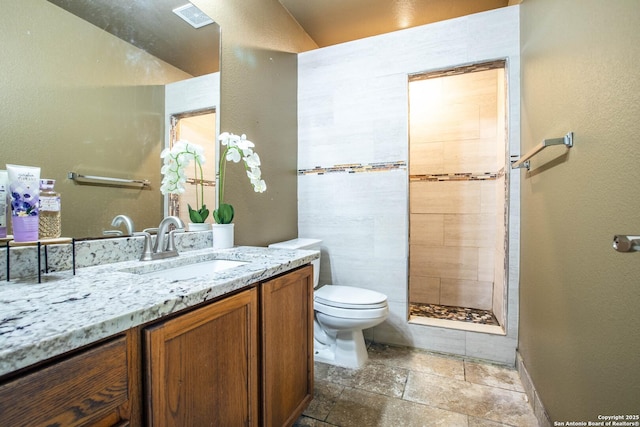 3606 Mill Mdw, San Antonio, TX 78247 - full bath featuring toilet, vanity, stone tile flooring, tiled shower, and a textured wall