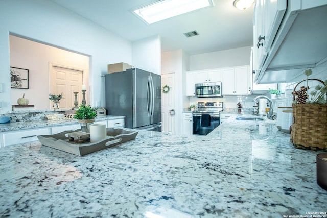 3606 Mill Mdw, San Antonio, TX 78247 - kitchen featuring appliances with stainless steel finishes, a sink, light stone counters, white cabinets, and decorative backsplash