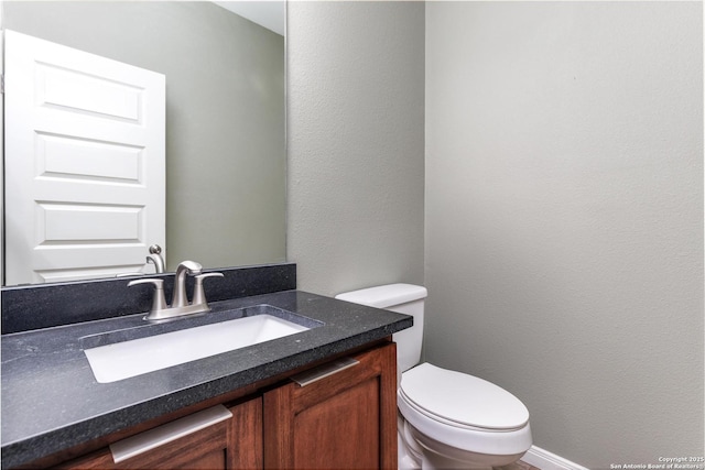 9527 Butterfly Bnd, San Antonio, TX 78224 - half bathroom featuring vanity, toilet, and a textured wall