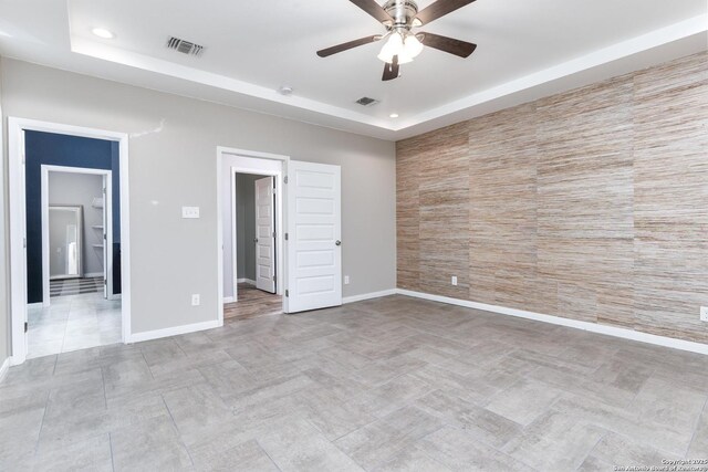 9527 Butterfly Bnd, San Antonio, TX 78224 - unfurnished bedroom with a raised ceiling, baseboards, recessed lighting, an accent wall, and a ceiling fan