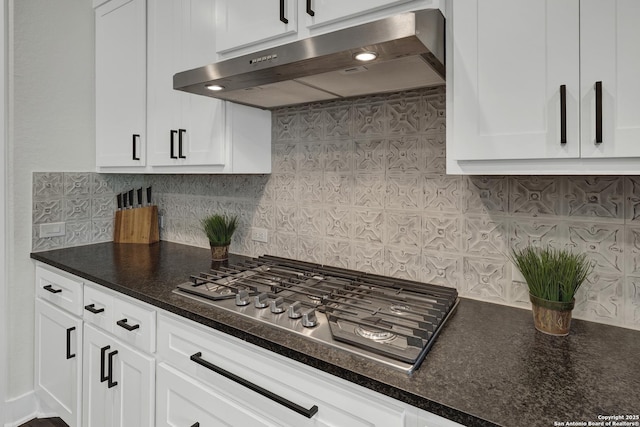 681 Treetop, New Braunfels, TX 78130 - kitchen featuring under cabinet range hood, stainless steel gas cooktop, white cabinetry, tasteful backsplash, and dark stone countertops