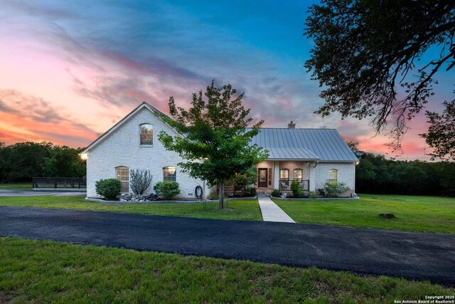 278 Stonebrook, New Braunfels, TX 78132 - view of front facade with a lawn, a chimney, a standing seam roof, and metal roof