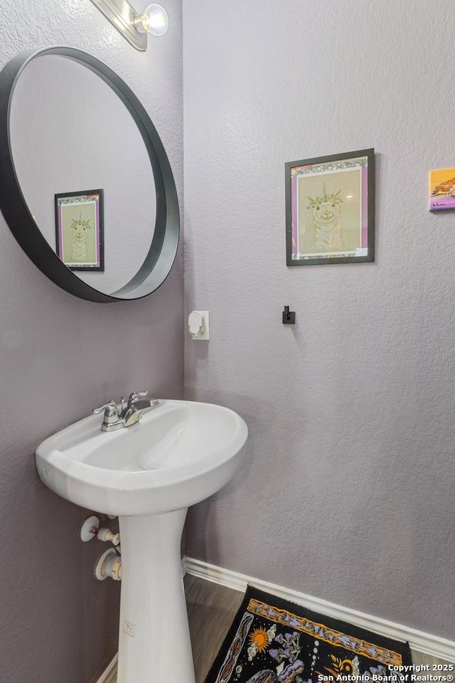 2079 Chelsea Grv, New Braunfels, TX 78130 - bathroom featuring wood finished floors, baseboards, and a sink