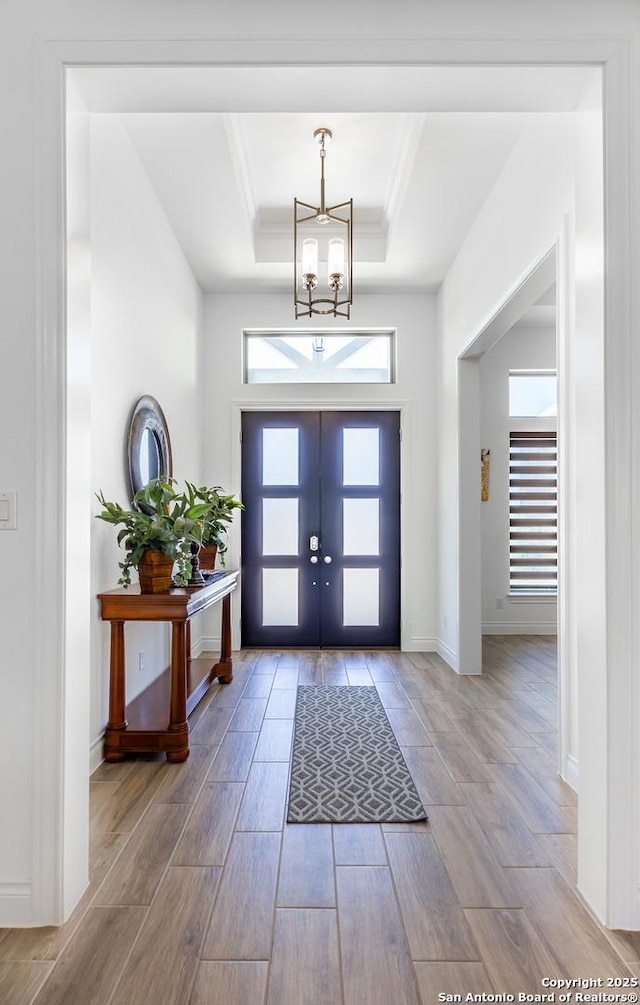 34784 High Gate, Bulverde, TX 78163 - entrance foyer featuring a raised ceiling, wood finished floors, a chandelier, ornamental molding, and baseboards
