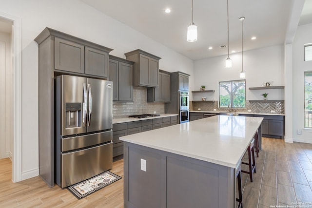 34784 High Gate, Bulverde, TX 78163 - kitchen with open shelves, stainless steel appliances, a center island, light wood-style floors, and backsplash