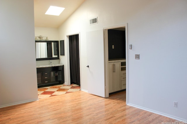 11815 Vance Jackson Unit 301, San Antonio, TX 78230 - unfurnished bedroom featuring high vaulted ceiling, light wood-style flooring, baseboards, a sink, and connected bathroom