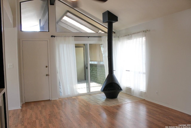 11815 Vance Jackson Unit 301, San Antonio, TX 78230 - spare room with a wood stove, wood finished floors, vaulted ceiling, and baseboards